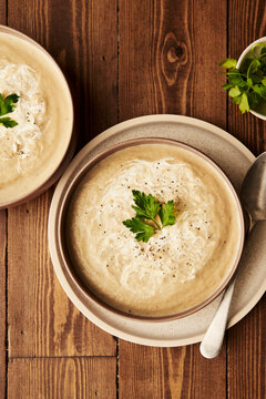 White Beetroot Soup with parsley on wooden table