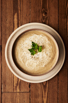 White Beetroot Soup with parsley on wooden table