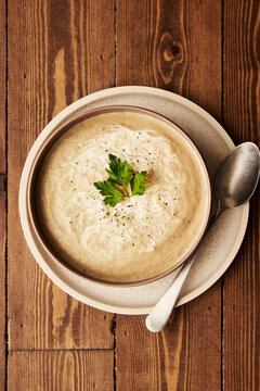 White Beetroot Soup with parsley on wooden table
