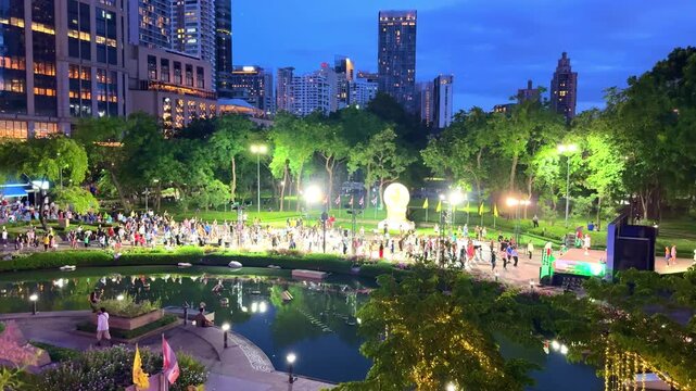 28 May 2026 Hundreds of People exercising in Benchasiri Park in Phrom Phong BKK Bangkok on a warm sunset night