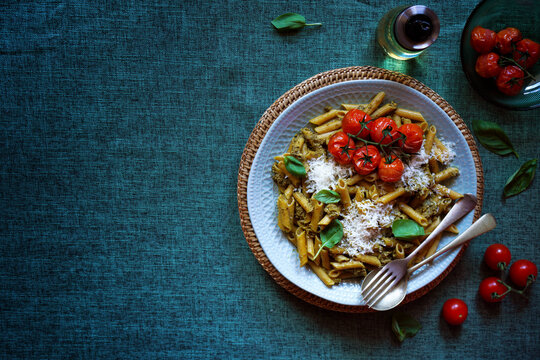 Plant-based diet high protein legume pasta with basil pesto sauce and roasted truss cherry tomatoes. Horizontal with negative copy space.