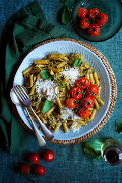 Plant-based diet high protein legume pasta with basil pesto sauce and roasted truss cherry tomatoes.