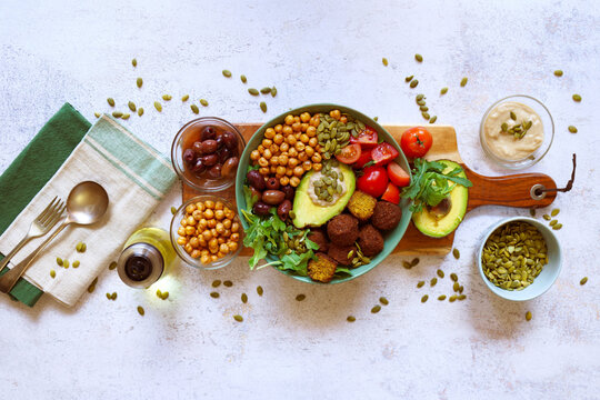 Super Healthy Mediterranean Bowl for Gut Health. Plant-based, High-Fiber, Longevity Diet, with Rocket Leaves, Falafel, Roasted Chickpeas, Kalamata Olives, Truss Tomatoes and Avocado.