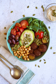 Super Healthy Mediterranean Bowl for Gut Health. Plant-based, High-Fiber, Longevity Diet, with Rocket Leaves, Falafel, Roasted Chickpeas, Kalamata Olives, Truss Tomatoes and Avocado.