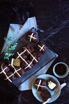 Chocolate Hot Cross Buns. Traditional Easter celebration yeast buns flatlay on dark marble table background.