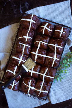 Chocolate Hot Cross Buns. Traditional Easter celebration yeast buns flatlay on dark marble table background.