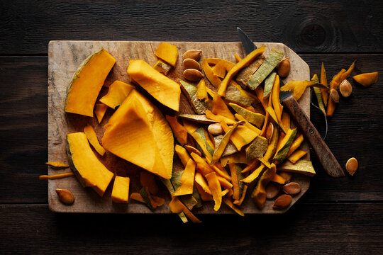 Pumpkin pieces on a wooden cutting board. Top view.