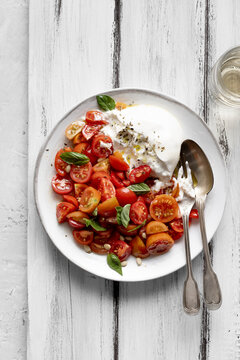 A simple Italian dish of burrata and cherry tomato hearts.