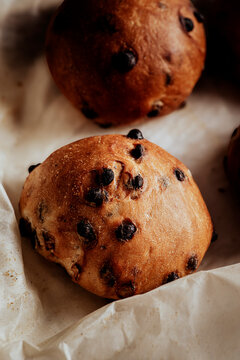 Freshly baked chocolate chip buns on parchment paper