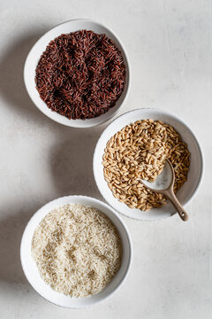 Three bowls with different types of rice.