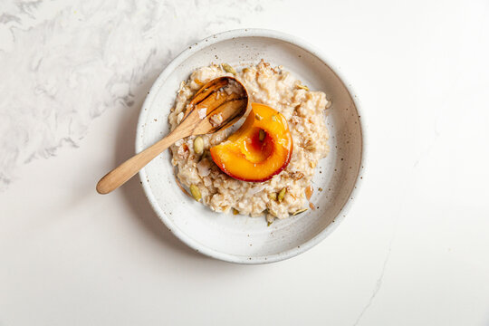 Stewed peach served over creamy oats with seeds and toppings