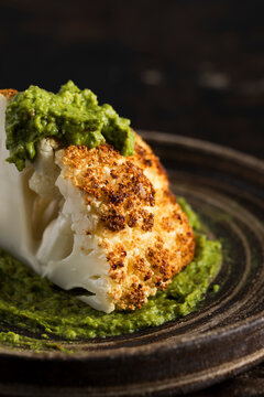 Roasted cauliflower served with a creamy green herb sauce.