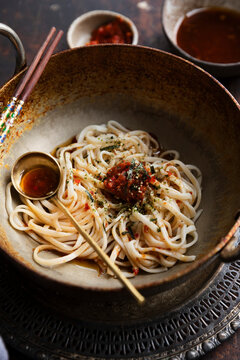 Spicy udon noodles topped with chili paste and seaweed garnish
