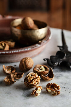 Cracked walnuts and shells scattered on a marble surface
