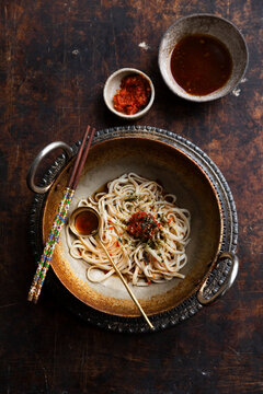 Spicy udon noodles topped with chili paste and seaweed garnish
