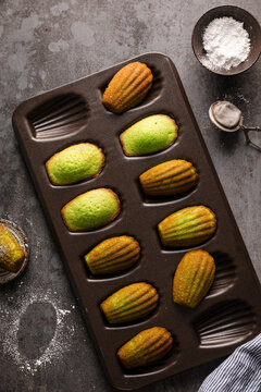 Pandan madeleines cooling in a baking tray