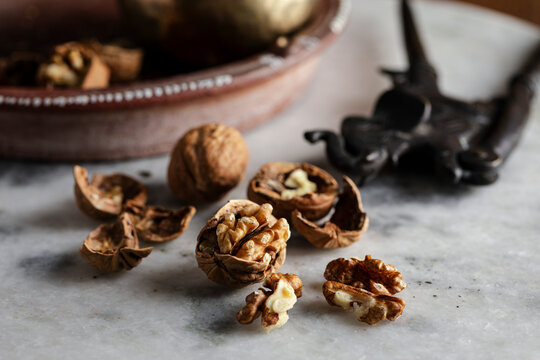 Cracked walnuts and shells scattered on a marble surface