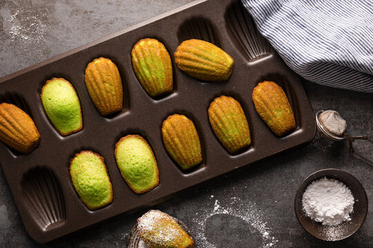 Pandan madeleines cooling in a baking tray