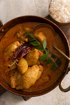 Singapore chicken curry with potatoes, chili, and fresh curry leaves