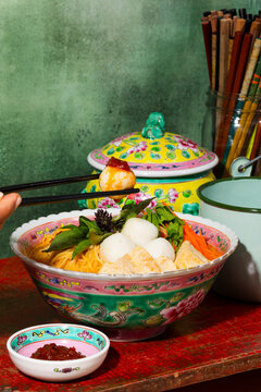 Fish ball noodle soup served in a colorful Peranakan bowl