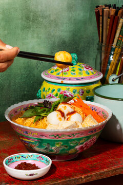 Fish ball noodle soup served in a colorful Peranakan bowl