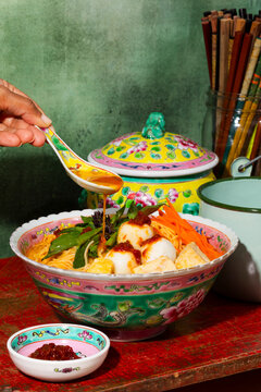 Savory broth of fish ball noodle soup served in a colorful Peranakan bowl