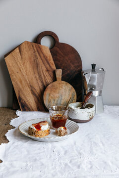 Sourdough bread with jam beside moka pot and wooden boards
