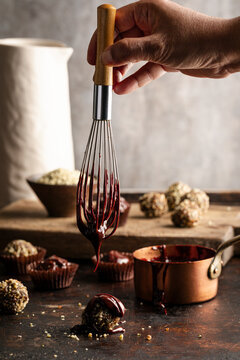 Chocolate drizzled over hemp ball on rustic kitchen surface