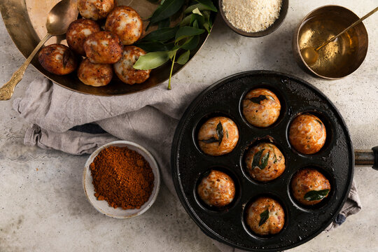 Kuzhi paniyaram in a cast-iron pan with spices