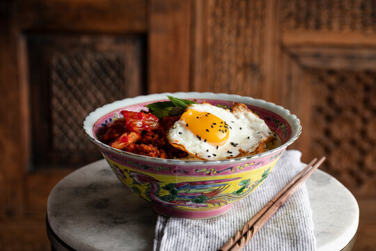 Spicy pork bulgogi served in a Peranakan bowl with a fried egg on top