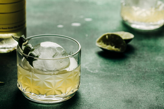 Elderflower Lillet cocktail with citrus twist and ice sphere.
