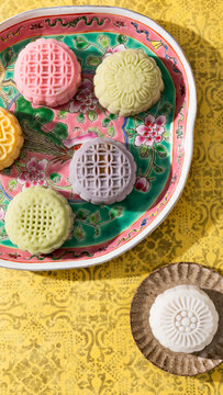 Colorful patterned mooncakes arranged on floral plate and small dish
