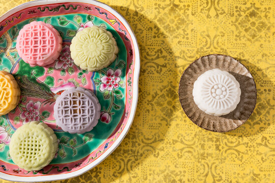 Colorful patterned mooncakes arranged on floral plate and small dish