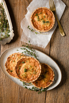 Mini quiches with herbs on rustic wooden table
