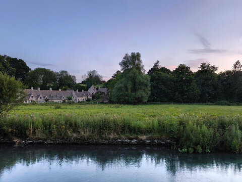 The tranquil riverside scenery with rich green foliage in the historic village of bibury