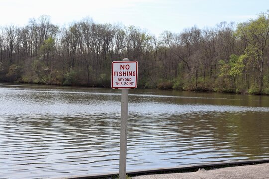 The no fishing sign at the lake in the park.