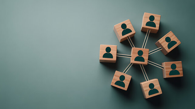 A group of wooden blocks with people icons connected by lines on a green background representing teamwork and network