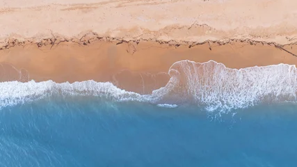 Fototapeten Luftbild Strand Natural coastal background showing ocean waves flowing across sandy beach from aerial perspective. Ideal visual for tourism marketing, holiday branding, and tropical lifestyle design.  © Hand Robot