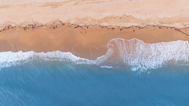 Natural coastal background showing ocean waves flowing across sandy beach from aerial perspective. Ideal visual for tourism marketing, holiday branding, and tropical lifestyle design.