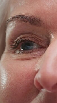 Close up portrait, old mature woman raises, opens her eyes smile look at camera, feels happy. Carefree pensioner portrait, good eyesight. Beauty senior female sight. Cosmetics for wrinkles, skin