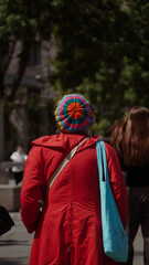 Fototapeta premium lady in a red coat and colorful hat photographed from behind