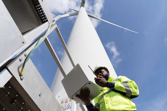 Wind turbine tower, Electrical system at wind turbines. Engineer or Electrician wearing safety uniform working at wind turbine, planning or operate new installation or maintenance