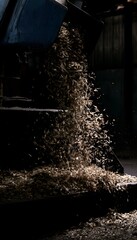 Obraz premium Raw wood shavings flow dramatically showcasing industrial processing and rich textural detail against a dark backdrop