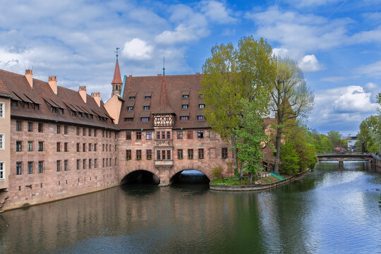 Hospital of the Holy Spirit over Pegnitz river in Nuremberg, Germany viewed from bridge. Exterior view, historic old town