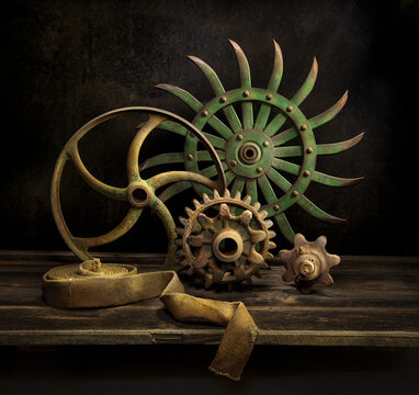 Still life of vintage wheels, gears, and belt from old farm machinery, circa 1900.