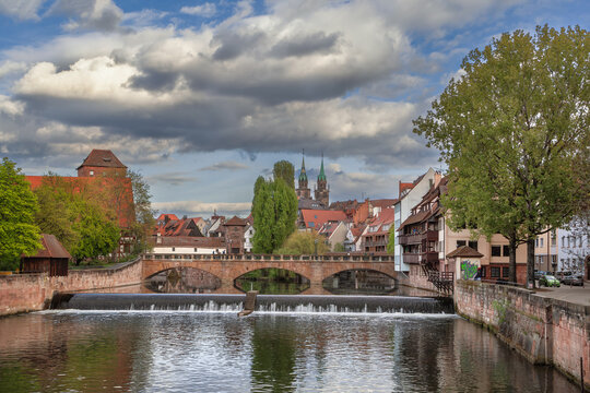 Historic Max Bridge over Pegnitz river in Nuremberg city center, Germany. Outside view, medieval architecture and cloudy sky