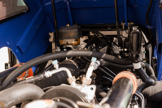 Close up of heavy duty vehicle engine compartment with blue chassis and mechanical components