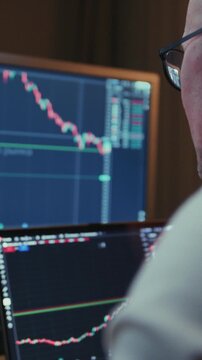 Man in trader home office. Monitor and laptop are on table. Trading program or exchange. Male analyzes candlestick charts for crypto market. Managing Investment portfolio, monitoring financial data