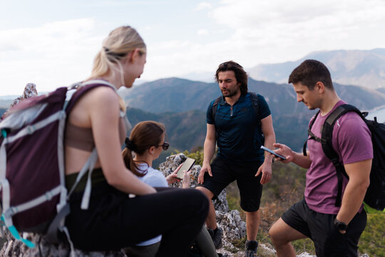 Group of friends hiking together on a mountain summit enjoying outdoor adventure and scenic views during a day hike in nature