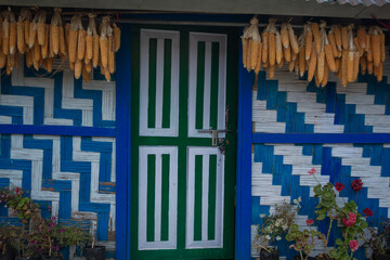 Obraz premium Traditional Himalayan house with hanging corn cobs, colorful woven walls, and rustic village charm